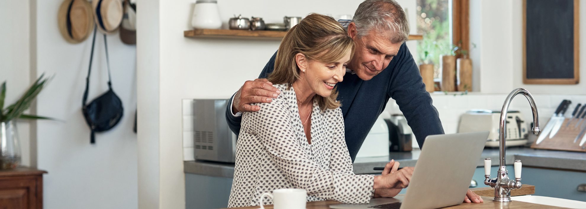 Couple looking at laptop on kitchen counter
